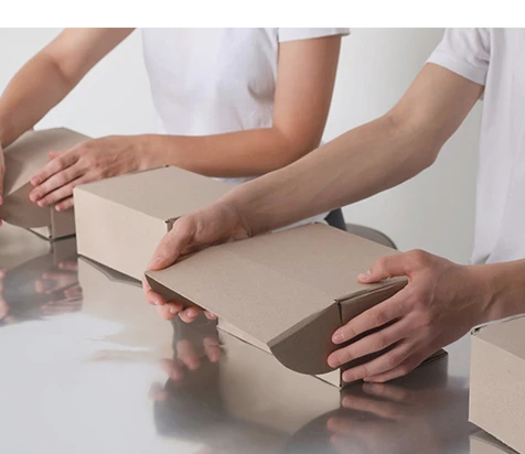 Primer plano de manos manipulando cajas de cartón